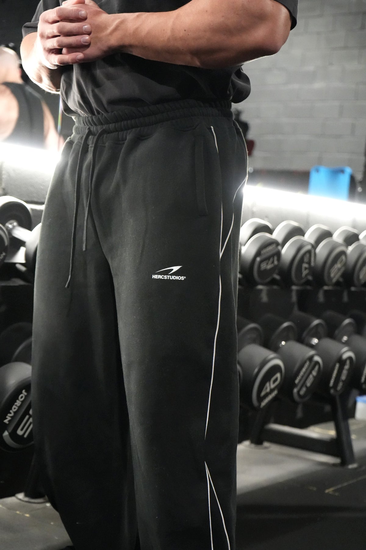 HERCSTUDIOS Reflective Sweatpants - Black gym model logo and piping detail