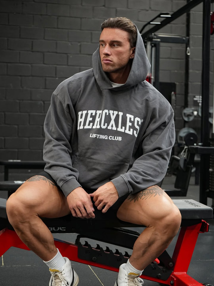 Athlete wearing a grey HERCXLES Lifting Club hoodie in the gym