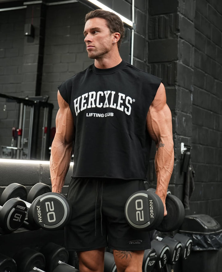Athlete holding dumbbells in a black HERCXLES Lifting Club cut-off
