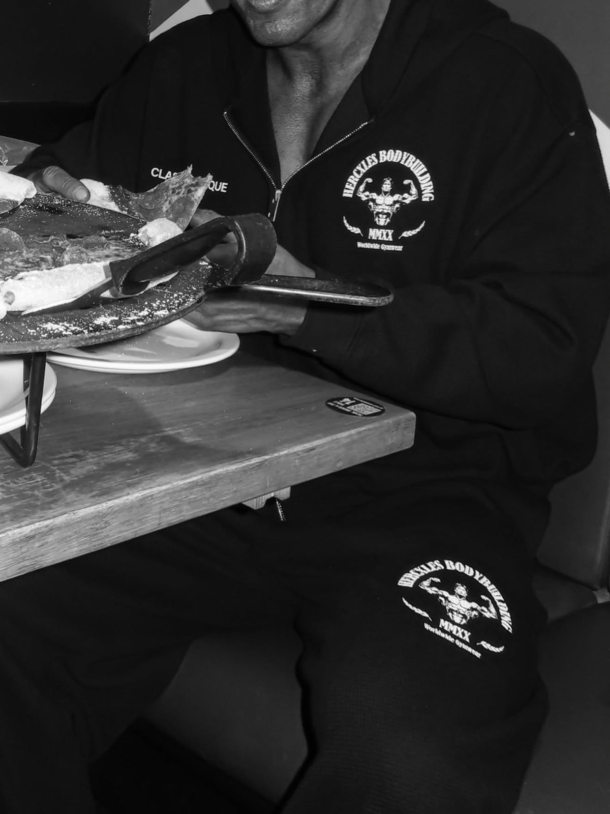 Worldwide Competitor Sweatpants - Black / White model seated in zip hoodie and matching joggers (p2)