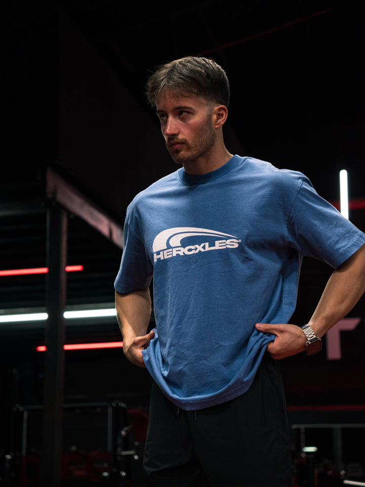 Athlete wearing a blue HERCXLES T-shirt in a gym
